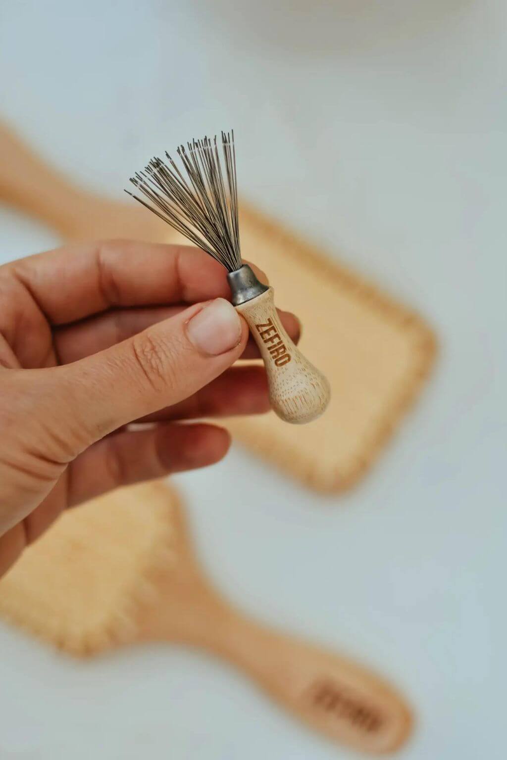 Close-up of fine metal bristles on a wooden brush cleaner